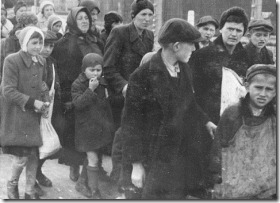 Jewish women and children from Subcarpathian Rus who have been selected for death at Auschwitz-Birkenau, walk to gas chambers